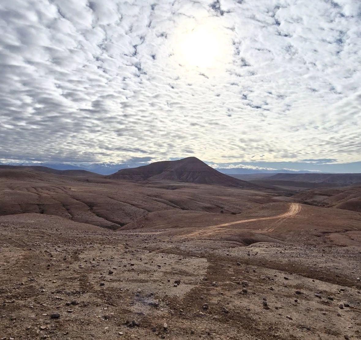 4x4 vehicle driving along a piste road toward a luxury camp in the Agafay Desert